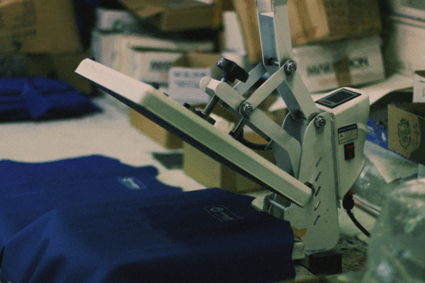 Heat press applying lettering to a workwear garment