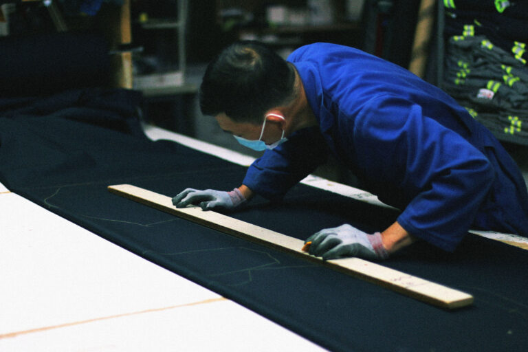 Drawing a garment pattern by hand at Northland Workwear in Edmonton